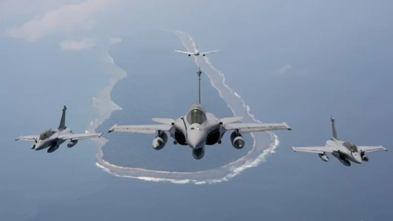 Drei Dassault Rafale Kampfflugzeuge fliegen in Formation vor einem Airbus A330 MRTT Tankflugzeug über einem Atoll im Ozean