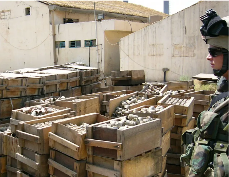 Ein Soldat des 1. Bataillons, 9. Feldartillerie, betrachtet am 5. Juni 2005 in einer Fabrik in Zafaraniya, Irak, mehr als 1.000 Submunitionen und 56.000 Zünder.