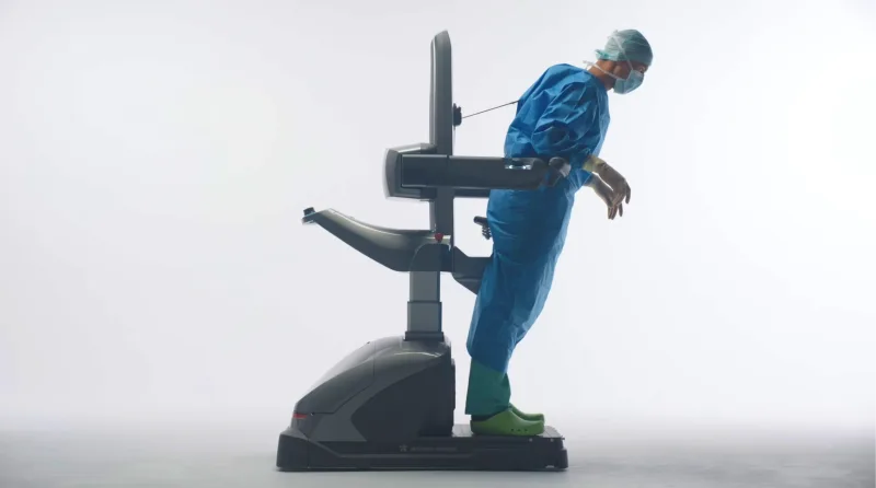 Chirurg in OP-Kleidung nutzt das ergonomische Unterstützungssystem NOAC zur Entlastung während eines chirurgischen Eingriffs