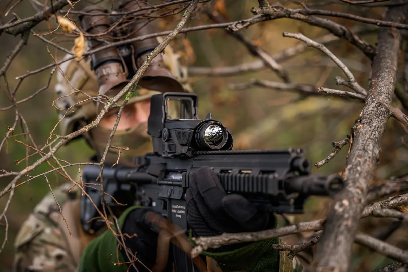 Ein Soldat zielt mit einem Sturmgewehr. Auf der Waffe ist das kombinierte Reflex- und Wärmebildvisier XTRAIM von Thales montiert.