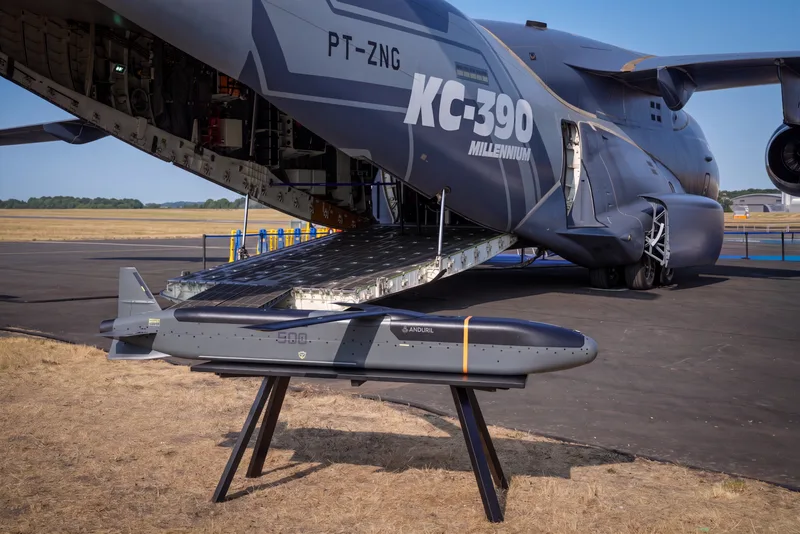 Anduril-Drohne auf einem Ausstellungsständer vor der geöffneten Heckklappe einer Embraer KC-390 Millennium auf einem Flugplatz
