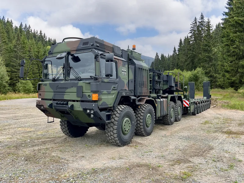 Rheinmetall HX81 Elefant 2 Sattelzugmaschine der Bundeswehr mit Tieflader auf unbefestigtem Gelände vor Waldkulisse
