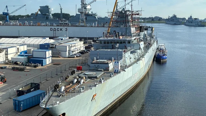 Fregatte Bayern der Deutschen Marine bei Instandsetzungsarbeiten an einem Kai mit Schwimmdock und Einsatzgruppenversorger im Hintergrund