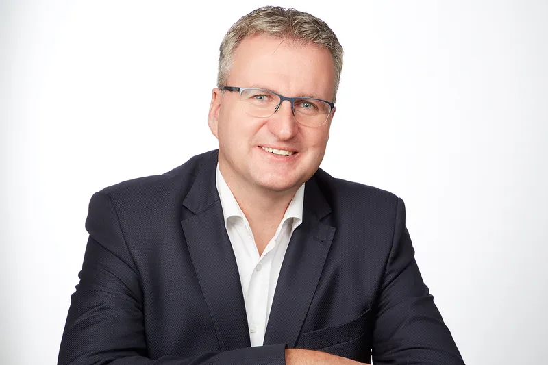 Ralph Petersen, Geschäftsführer von CustomCells, im dunklen Sakko und weißen Hemd vor weißem Hintergrund