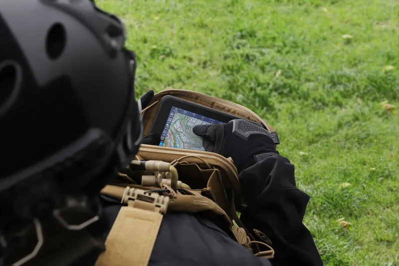 Soldat eines gemeinsamen Feuerunterstützungsteams bedient im Gelände ein robustes Tablet zur Koordinierung von Luftnahunterstützung