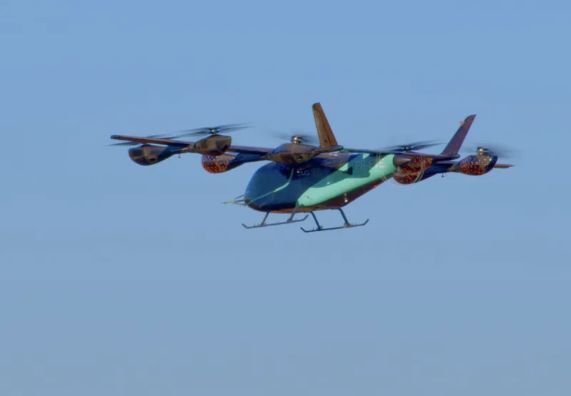 Prototyp des elektrischen Senkrechtstarters Eve Air Mobility mit Kennzeichen PR-EVE im Flug vor blauem Himmel