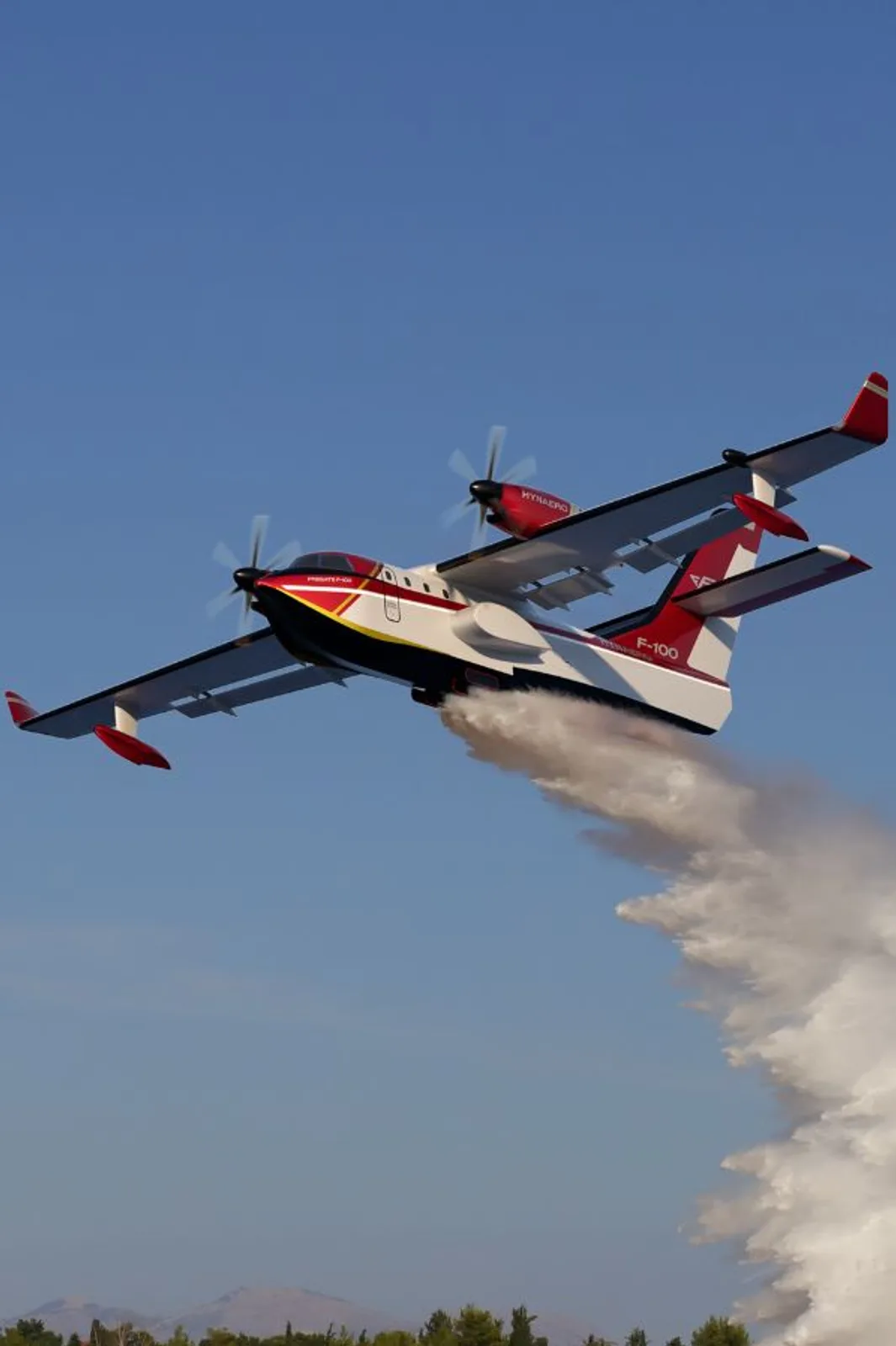 Die grafische Darstellung zeigt das geplante zweimotorige Löschflugzeug des Typs Frégate-F100 des französischen Herstellers Hynaero im Flug beim Abwurf von Löschwasser.