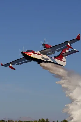 Die grafische Darstellung zeigt das geplante zweimotorige Löschflugzeug des Typs Frégate-F100 des französischen Herstellers Hynaero im Flug beim Abwurf von Löschwasser.