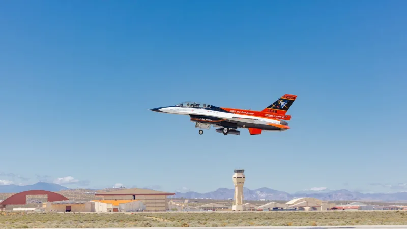 Lockheed Martin X-62A VISTA Testflugzeug im Tiefflug mit ausgefahrenem Fahrwerk über einer Militärflugplatz-Landebahn