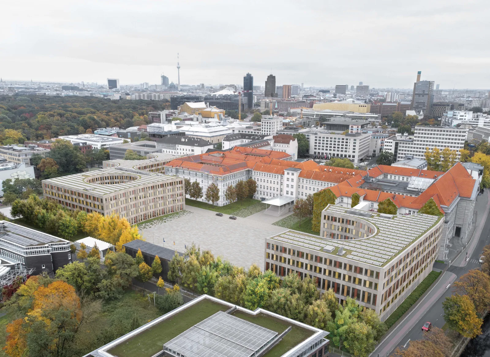 Eine architektonische Visualisierung zeigt den Entwurf zur baulichen Weiterentwicklung des Berliner Dienstsitzes des Bundesministeriums der Verteidigung (BMVg) im historischen Bendlerblock. Die Darstellung zeigt neue Bürogebäude mit Solaranlagen und begrünten Dächern, die sich um den zentralen Paradeplatz gruppieren.