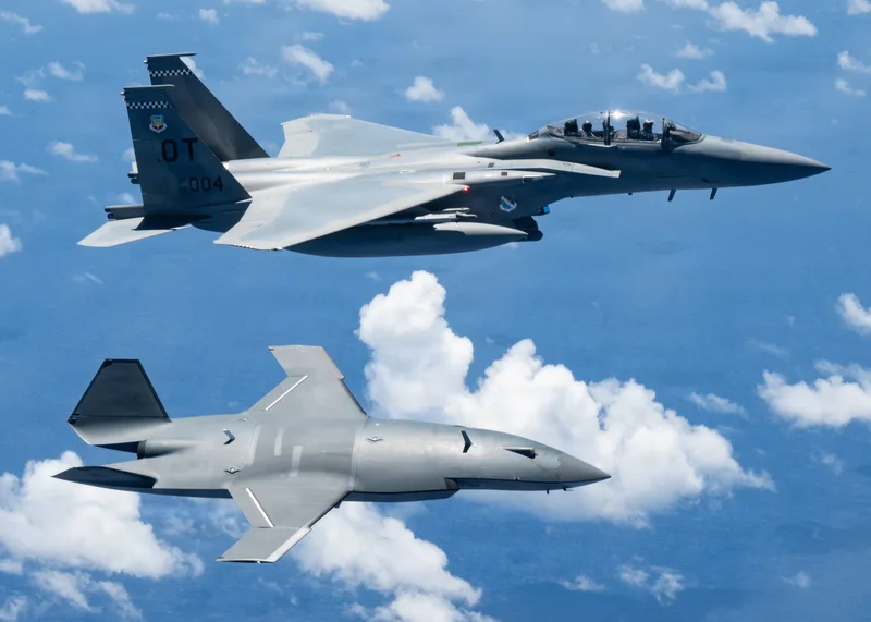 Boeing F-15EX Eagle II der US Air Force fliegt während der Übung Valiant Shield in Formation mit einer Boeing MQ-28 Ghost Bat Drohne