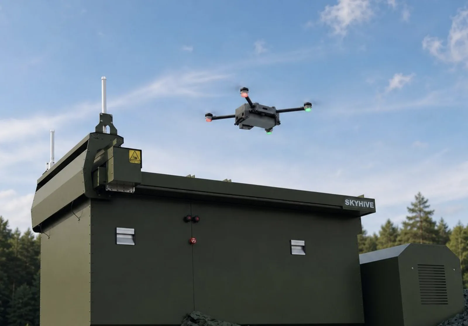 Unbemannter Quadrocopter schwebt über der olivgrünen Drohnenstation Skyhive von Tective Robotics vor einer Waldkulisse