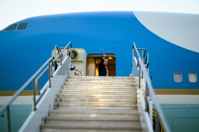 Donald Trump winkt aus der Tür der Air Force One, einer Boeing VC-25, auf einer Passagiertreppe