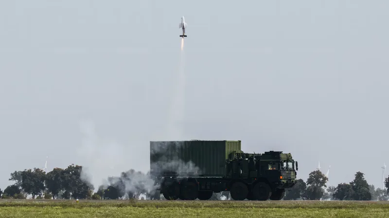 Rheinmetall MAN HX-LKW startet einen Flugkörper aus einem Container mit sichtbarer Rauchspur in den Himmel