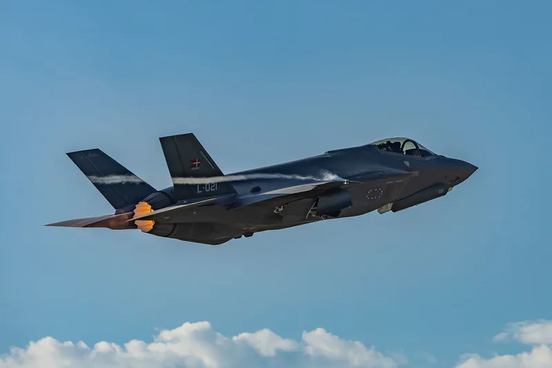 Dänische Lockheed Martin F-35A Lightning II mit Kennung L-021 im Steigflug mit gezündetem Nachbrenner vor blauem Himmel