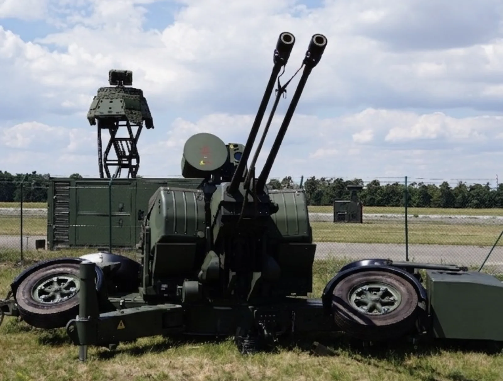 Passiver Sensor: Rheinmetall und Hensoldt demonstrieren erfolgreiche Integration passiver Sensortechnologie in modernes Luftverteidigungssystem: 35-mm-Zwillings-Flugabwehrkanone Oerlikon-GDF von Rheinmetall in Stellung mit einer Radaranlage zur Luftraumüberwachung im Hintergrund