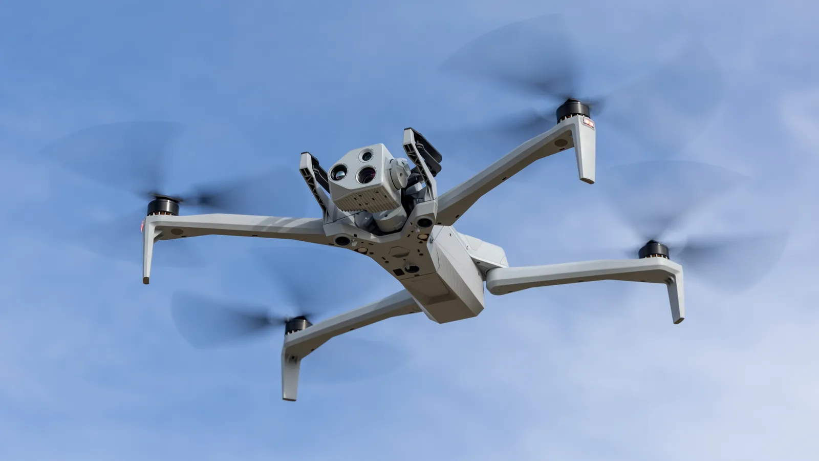 Drohnen-Exporte: Aufklärungsdrohne Skydio X10 mit schwenkbarer Sensor- und Kameraeinheit im Flug vor blauem Himmel