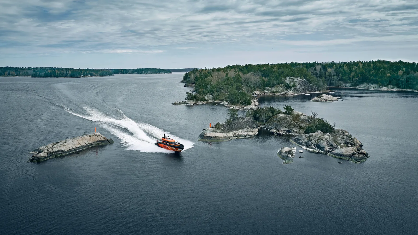 Scania präsentiert sein breites Angebot für die Schifffahrt auf der SMM 2026 Orange-schwarzes Patrouillenboot der finnischen Marine bei schneller Fahrt durch eine felsige Schärenlandschaft