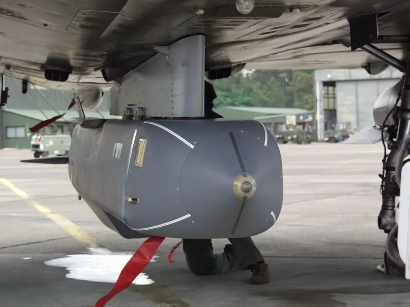Techniker wartet einen MBDA SCALP Marschflugkörper unter der Tragfläche eines Kampfflugzeugs auf einem Flugplatz