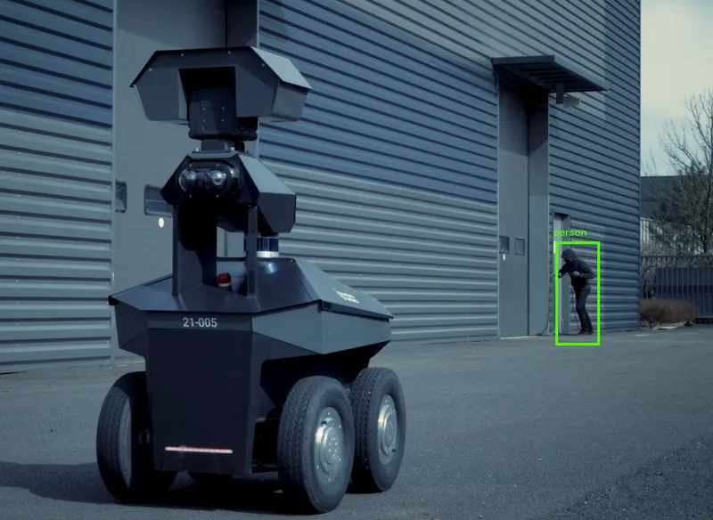 Sicherheitsroboter GR100 mit automatischer Personenerkennung vor einem Industriegebäude