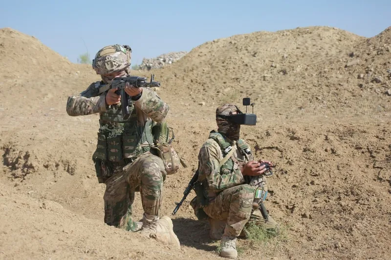 Usbekische Truppen beim Training, wobei ein Bediener eine FPV-Drohne steuert.