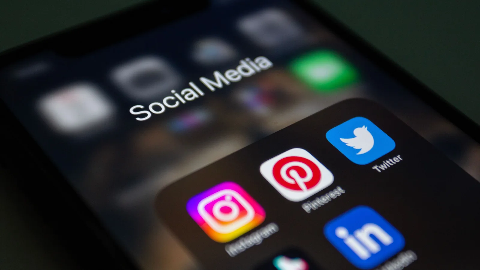 Smartphone-Bildschirm mit geöffnetem Ordner und App-Symbolen von Instagram, Pinterest, Twitter und LinkedIn