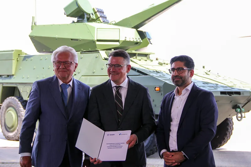 Vertreter der hessischen Landesregierung und Rheinmetall präsentieren eine Absichtserklärung vor einem Boxer-Radpanzer mit Skyranger