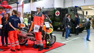 BMW-Einsatzmotorrad der DRK-Motorradstaffel Sachsen und gepanzertes Sanitätskettenfahrzeug Hägglunds BV 206S auf einer Fachmesse
