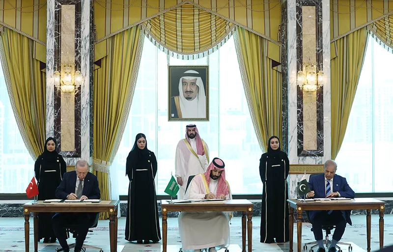 Recep Tayyip Erdoğan, Mohammed bin Salman und Shehbaz Sharif unterzeichnen Regierungsabkommen in einem Saal in Saudi-Arabien