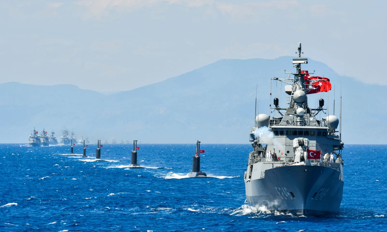 Ägäis – Der ewige Streit: Fregatte TCG Salihreis (F 246) führt eine Formation türkischer Kriegsschiffe und U-Boote vor einer bergigen Küste an