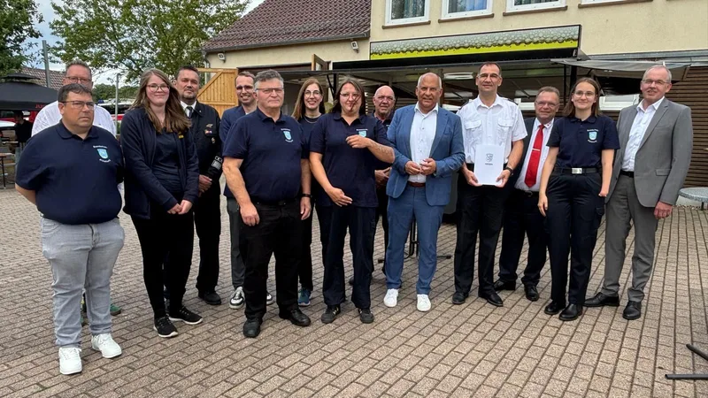Hessen: Vertreter aus Politik und Verwaltung überreichen einen Förderbescheid des Landes Hessen an Mitglieder der Brandschutzerziehung in Wabern-Unshausen