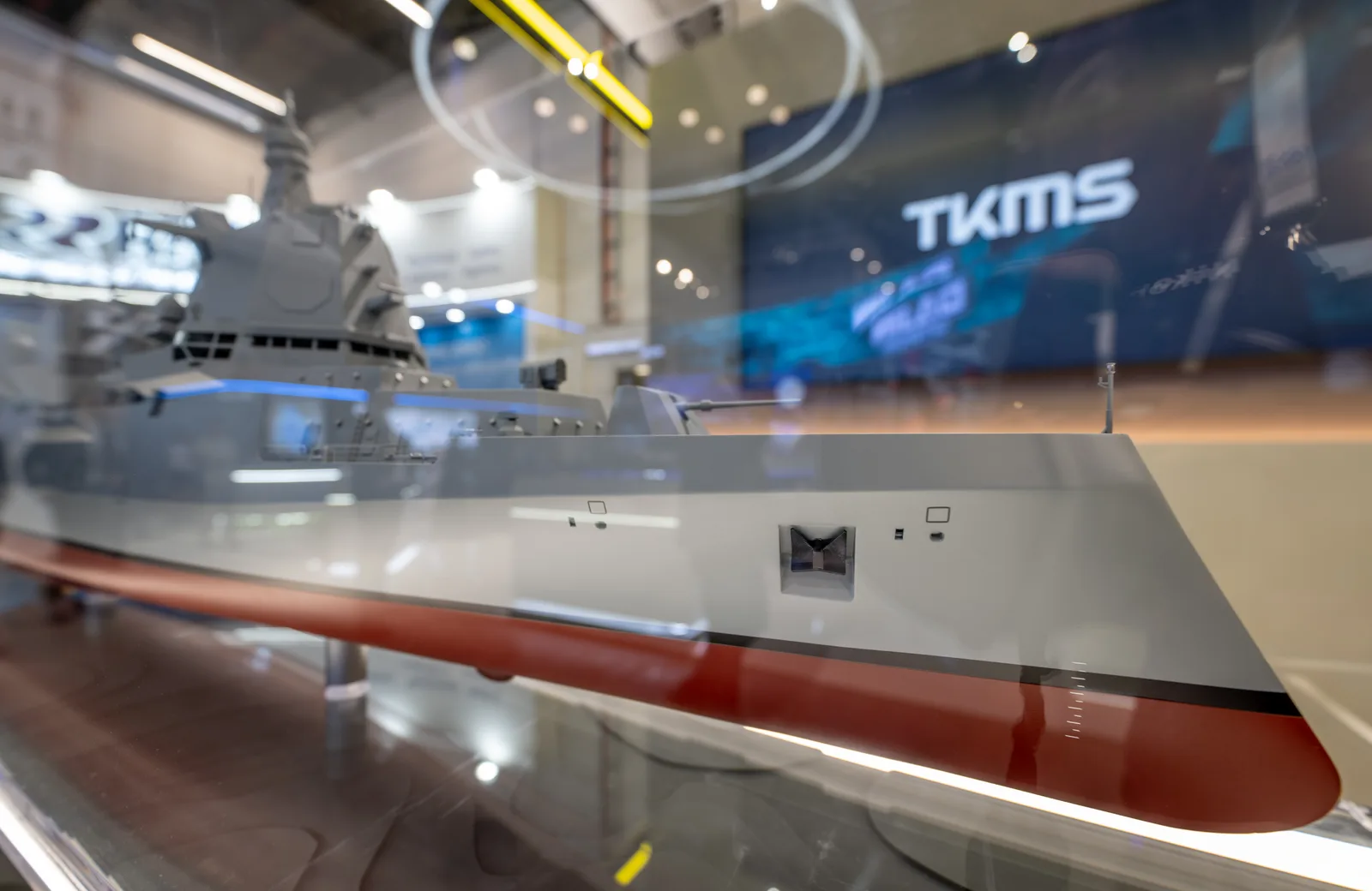 Modell eines Überwasserkampfschiffs von thyssenkrupp Marine Systems in einer Vitrine auf einer Fachmesse