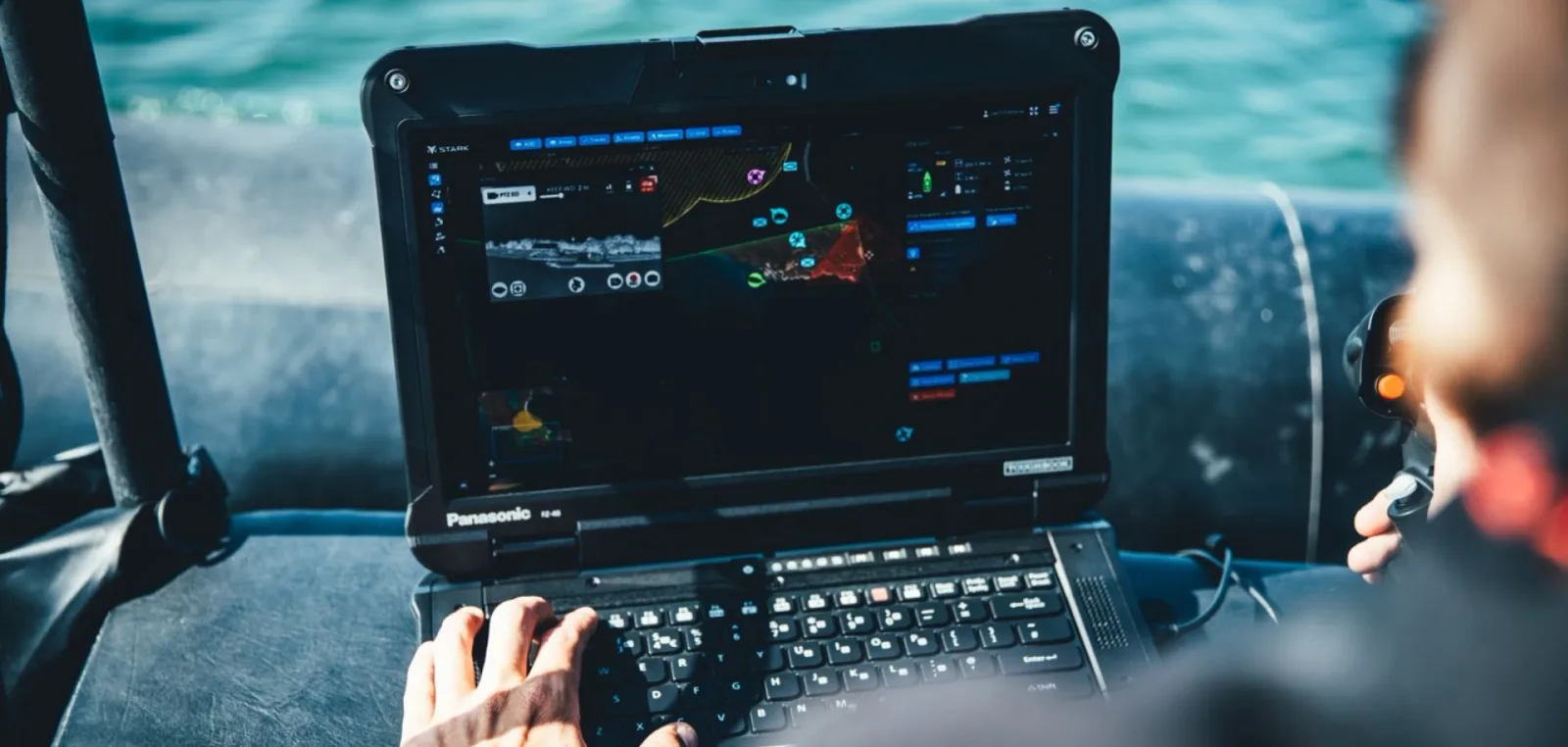 Einsatzkraft bedient ein Panasonic Toughbook FZ-40 mit maritimer Führungssoftware von Stark Defence an Bord eines Bootes