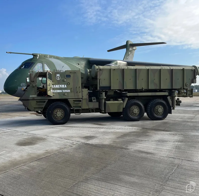 The modified ASTROS LMU equipped with MANSUP missile launchers operated by the Brazilian Marine Corps, alongside a Brazilian Air Force Embraer KC-390.