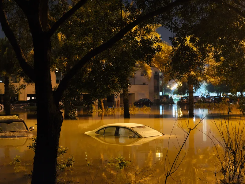 MESHFREE: Überschwemmtes Wohngebiet bei Nacht mit im Wasser versunkenen Fahrzeugen und einer fast untergegangenen weißen Limousine