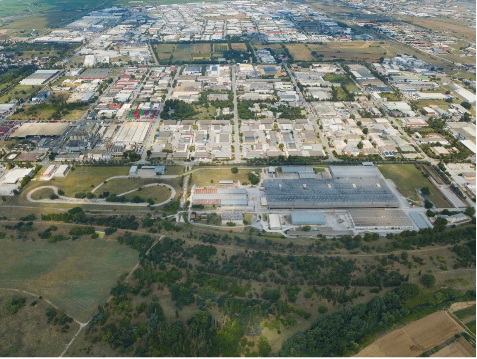 Luftaufnahme des ELVO-Werksgeländes mit Produktionshallen und Teststrecke im Industriegebiet Sindos bei Thessaloniki