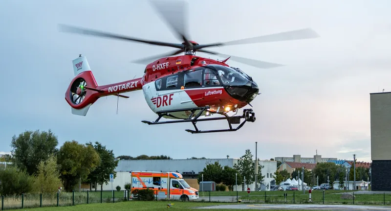 Notfallreform: Rettungshubschrauber Airbus H145 der DRF Luftrettung landet vor einem bereitstehenden Rettungswagen auf einem Klinikgelände