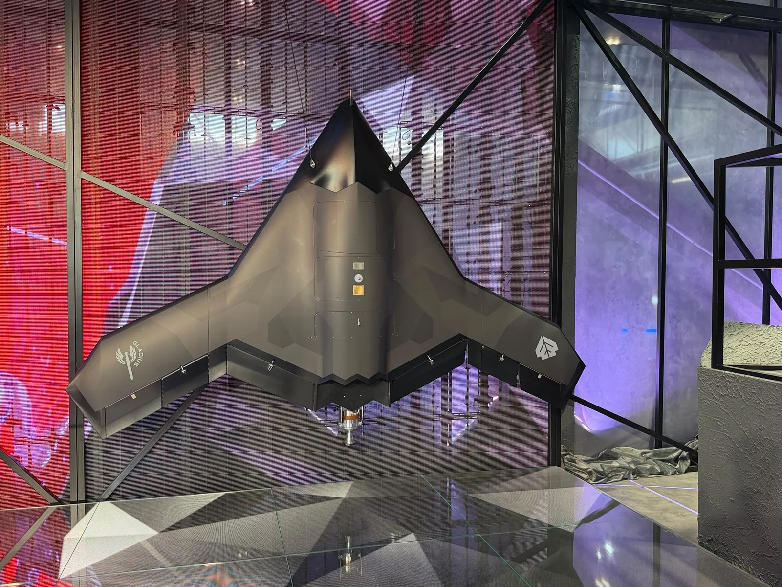 Unbemanntes Luftfahrzeug Gladius der WB Group auf einer Ausstellungsfläche mit sichtbaren Herstellerlogos auf den Tragflächen