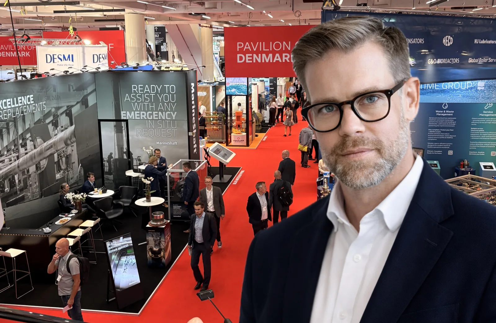 Mann mit Brille vor dem dänischen Gemeinschaftsstand mit Firmenlogos von DESMI und MarineShaft auf einer Fachmesse