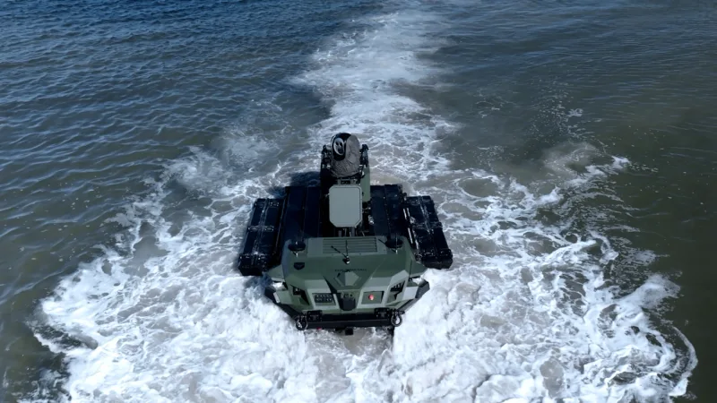 Unbemanntes amphibisches Landfahrzeug Rheinmetall Mission Master fährt schwimmend durch ein Gewässer