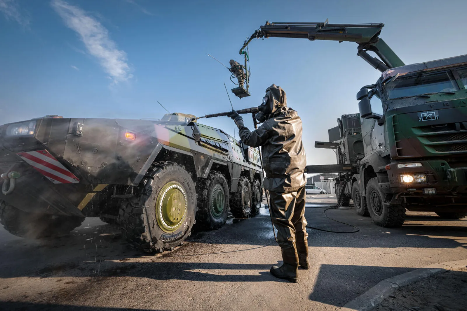 Soldaten der Bundeswehr dekontaminieren einen GTK Boxer in Litauen mithilfe der Hebevorrichtung eines Iveco Trakker Lkw