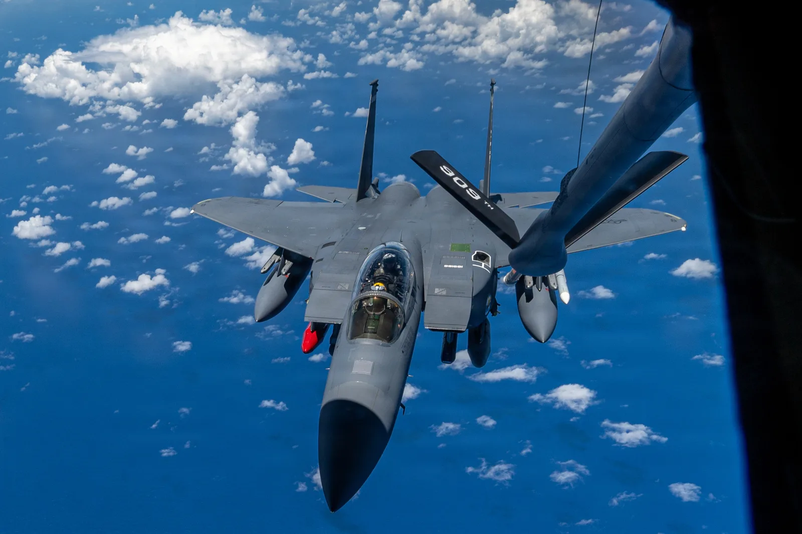 McDonnell Douglas F-15 Kampfflugzeug der US Air Force nähert sich dem Tankausleger eines Tankflugzeugs über dem Meer zur Luftbetankung