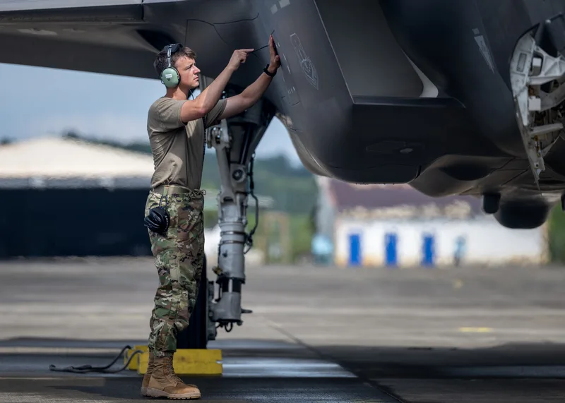 Wartungstechniker der Luftwaffe überprüft eine Wartungsklappe an der Außenhaut eines Kampfflugzeugs Lockheed Martin F-35 auf einem Flugfeld