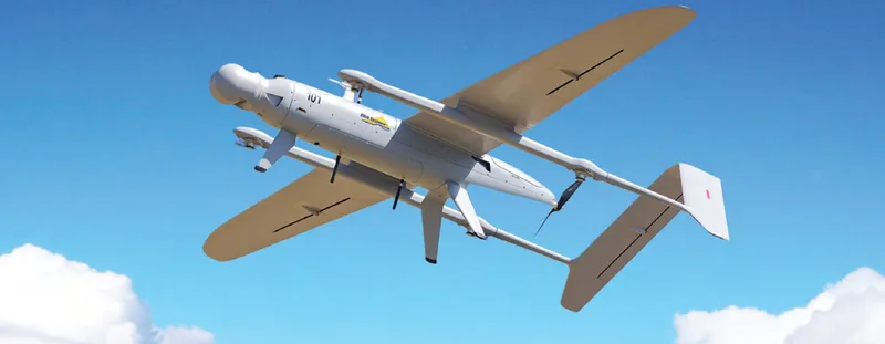 Aufklärungsdrohne Skylark von Elbit Systems mit Vertikalstart-Rotoren und elektrooptischem Sensor im Flug vor blauem Himmel