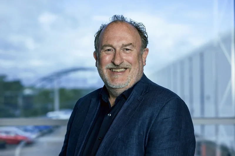 Ian Bell von Pearson Engineering im Porträt vor einer Fensterfront