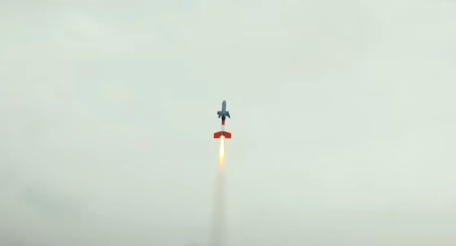 Die neue TI-03 Hyperion von Tytan startet mit Raketenbooster. Lenkflugkörper mit orangefarbenem Heck steigt mit sichtbarem Triebwerksstrahl steil in einen bewölkten Himmel auf