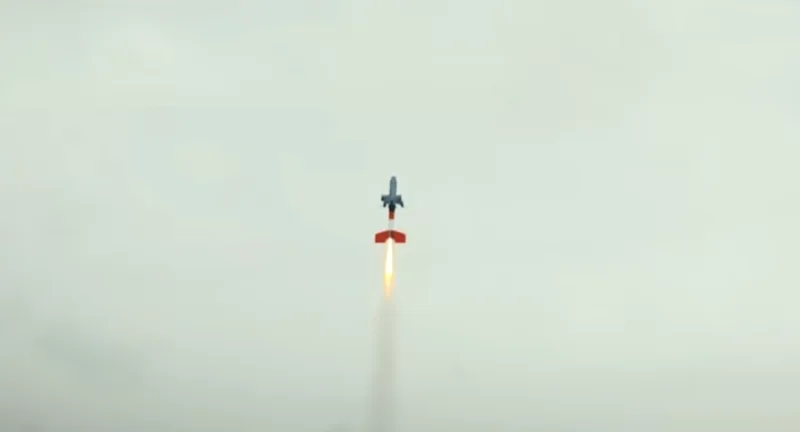 Die neue TI-03 Hyperion von Tytan startet mit Raketenbooster. Lenkflugkörper mit orangefarbenem Heck steigt mit sichtbarem Triebwerksstrahl steil in einen bewölkten Himmel auf