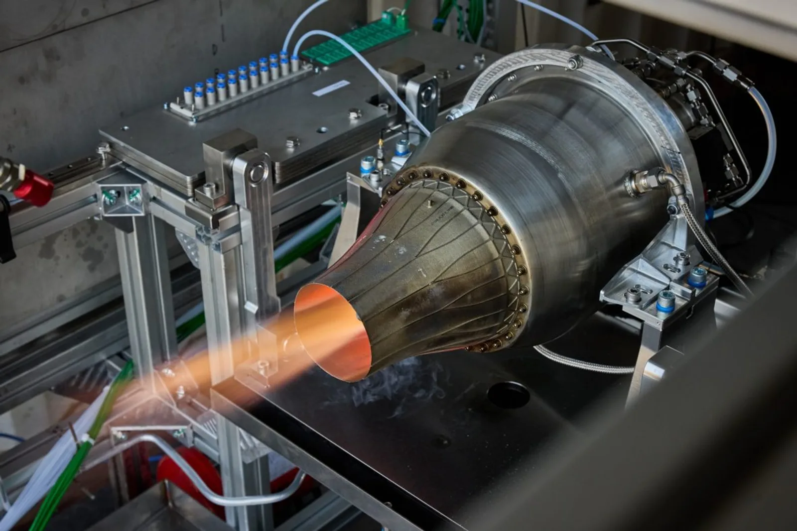 Turbojet-Triebwerk im Testbetrieb auf einem Prüfstand mit glühender Düse und zahlreichen Zuleitungen sowie Sensoren