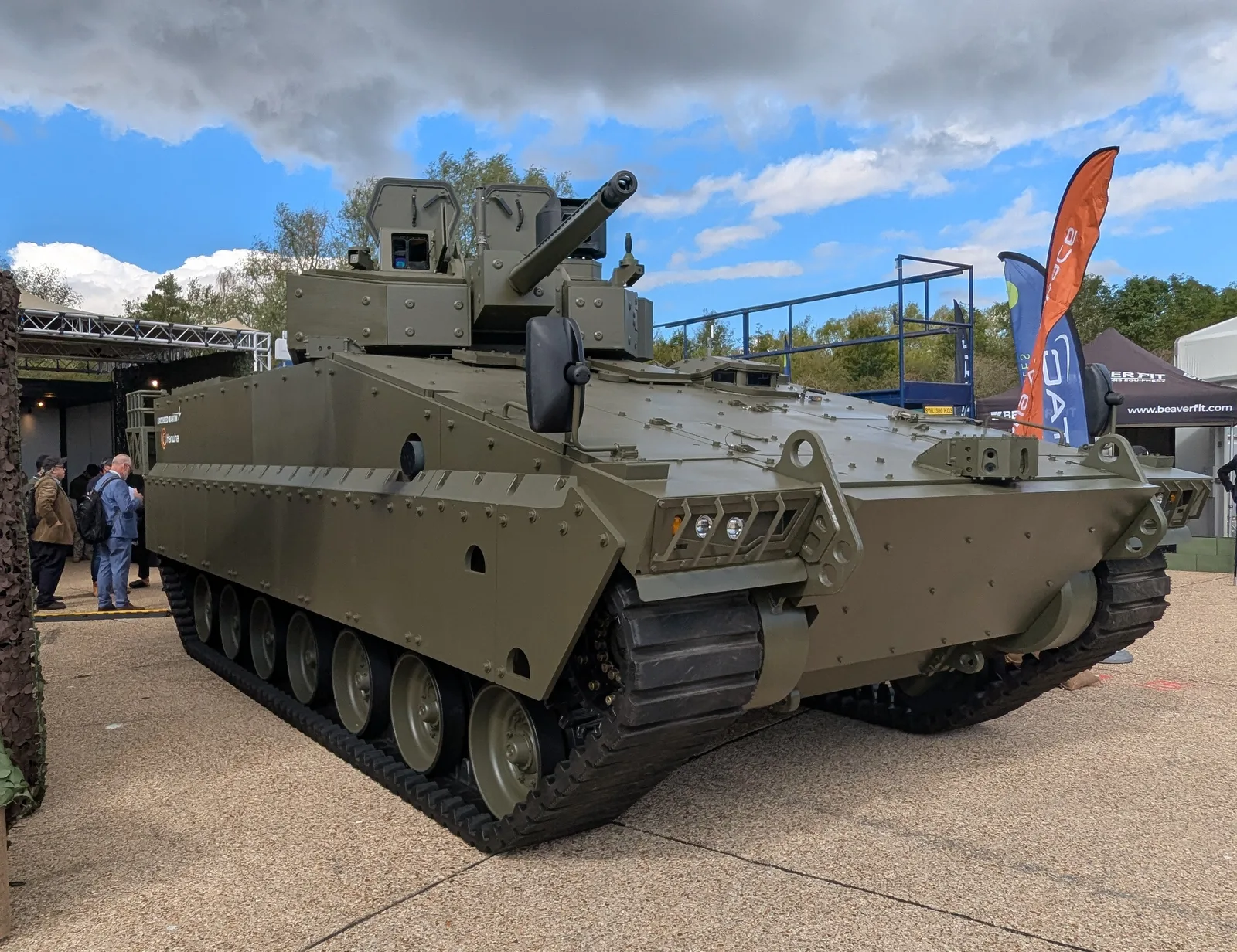 Schützenpanzer AS21 Redback von Hanwha und Lockheed Martin als Exponat auf einer Fachmesse mit Besuchern im Hintergrund