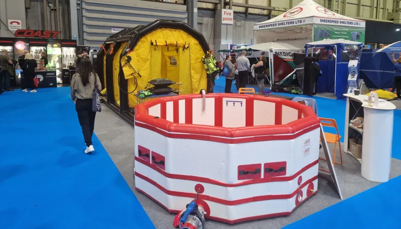 Rot-weißes Auffangbecken und gelbes Dekontaminationszelt von Sheerspeed Shelters Ltd auf einer Katastrophenschutz-Fachmesse
